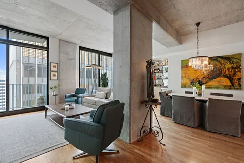 a living room with furniture and a view of kitchen