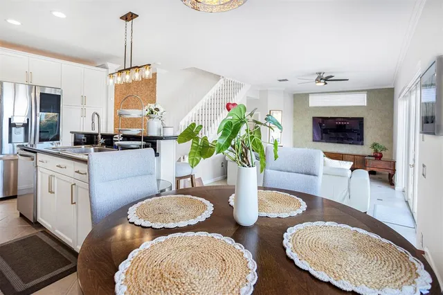 a dining room with furniture a chandelier and wooden floor