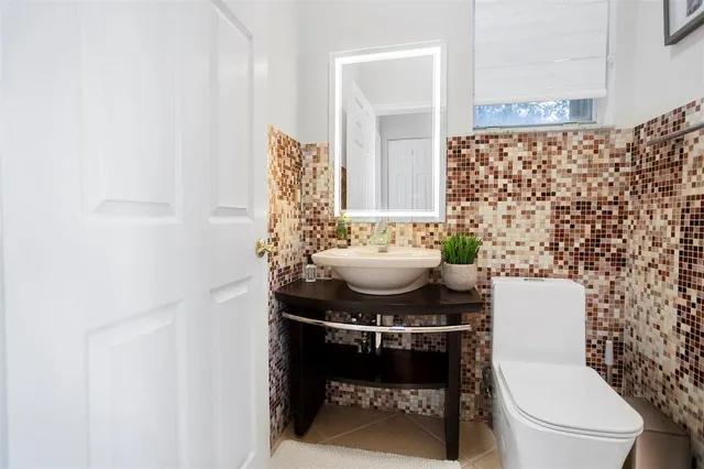 a bathroom with a sink toilet and a mirror