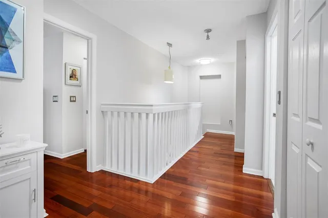 a view of a hallway with wooden floor and staircase