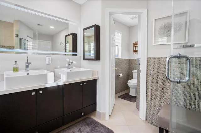 a bathroom with a sink vanity mirror and toilet