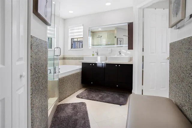a bathroom with a sink vanity granite tub and shower