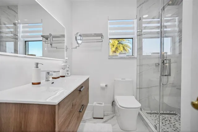 a bathroom with a sink a toilet and shower