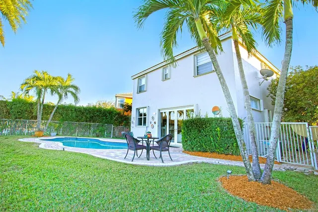 a house view with swimming pool and garden space