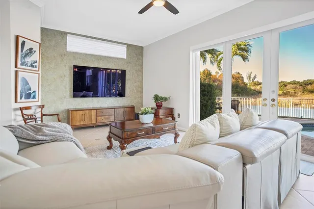a living room with furniture floor to ceiling window hardwood floor and a flat screen tv