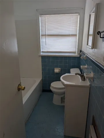 an empty room with wooden floor chandelier fan and windows