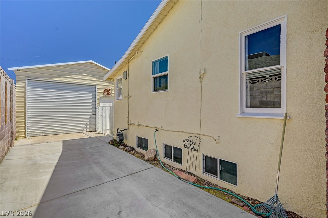 629 L Avenue Boulder City, NV 89005 - Photo 43 of 46 View of home's exterior with stucco siding, an outdoor structure, concrete driveway, and a detached garage