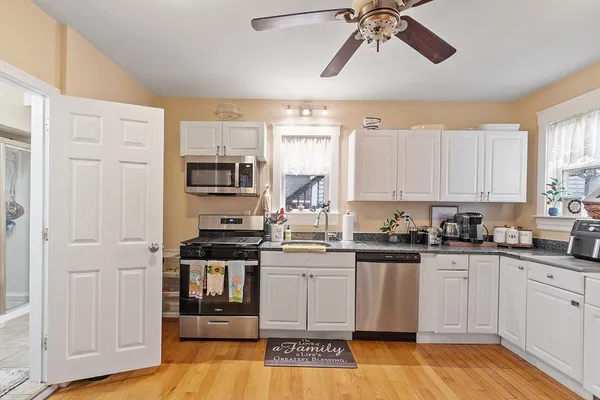 a kitchen with stainless steel appliances a refrigerator a sink a stove a dining table and chairs