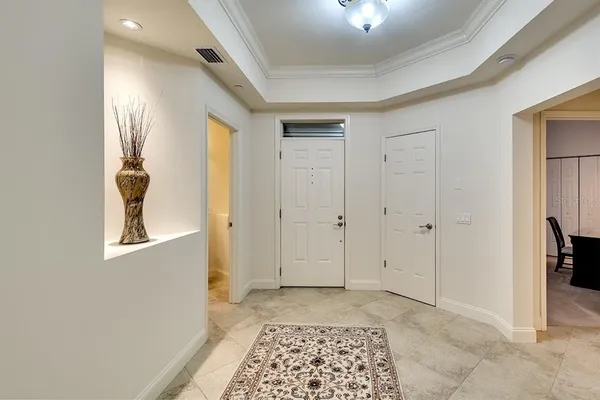 a view of a hallway with windows and chandelier