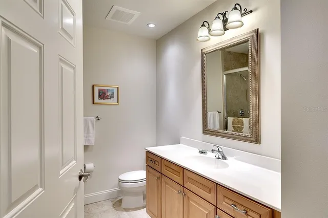 a bathroom with a sink vanity mirror and toilet
