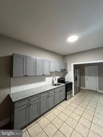 a kitchen with a sink a stove and cabinets