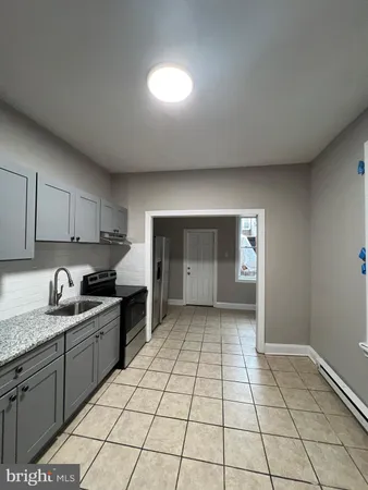 a kitchen with a sink a stove and cabinets