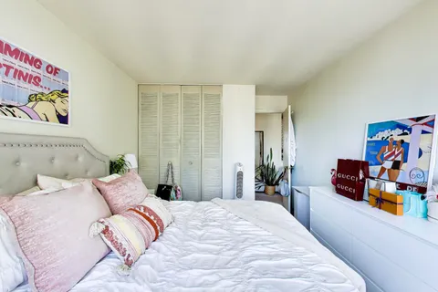 a bedroom with a bed a flat screen tv and a large window