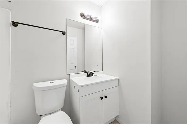 a bathroom with a toilet sink vanity and mirror