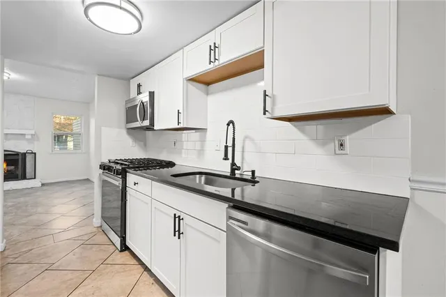 a kitchen with stainless steel appliances granite countertop a sink and a stove