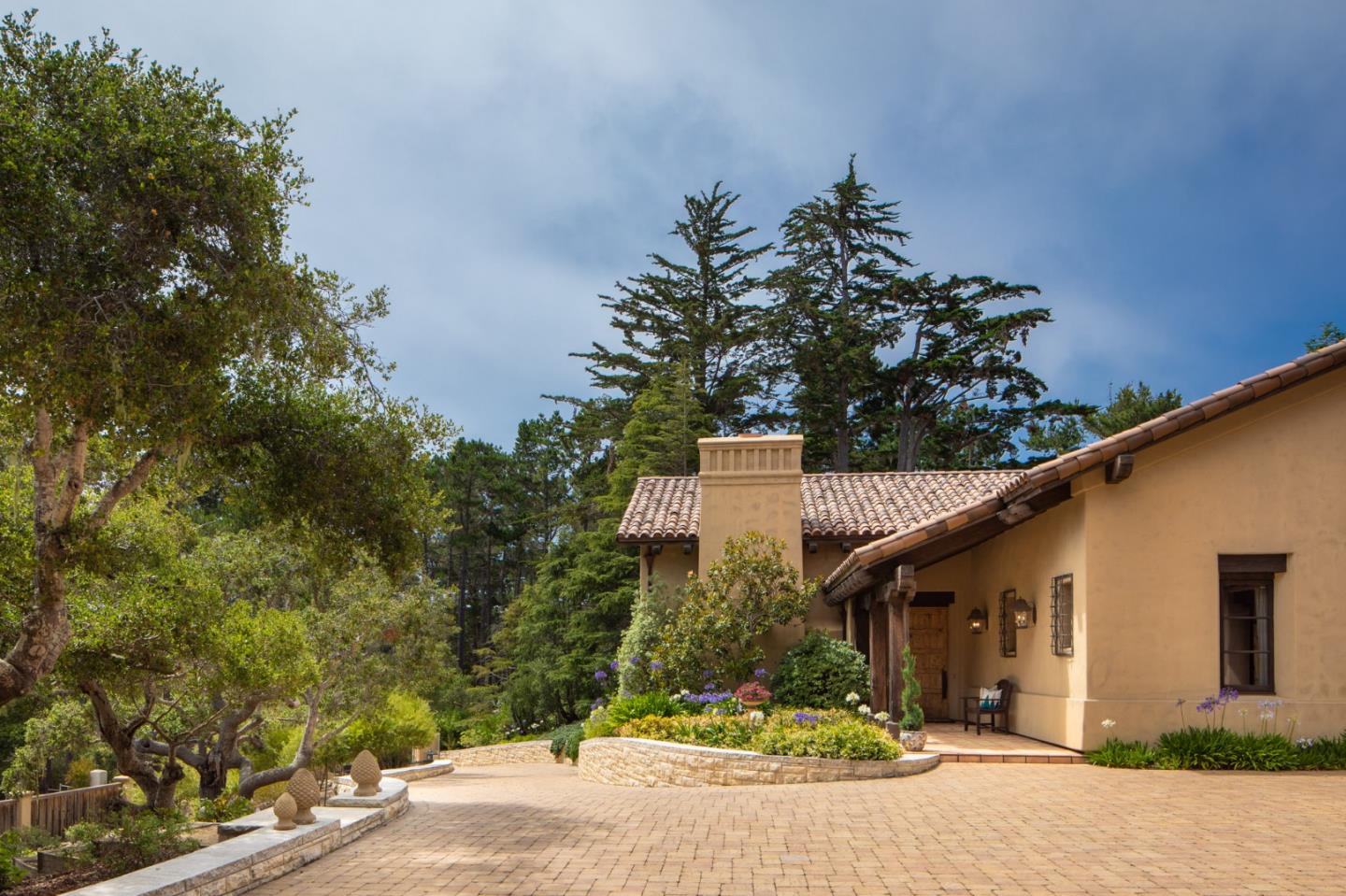 1425 Oleada Road Pebble Beach, CA 93953 - Photo 20 of 26 a front view of a house with a yard and garage
