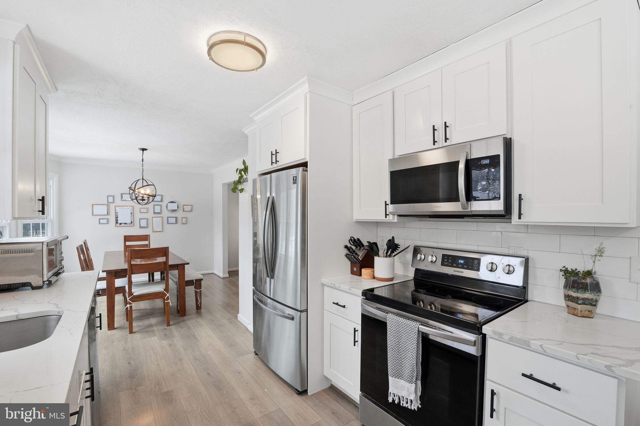 2207 Victor Court Silver Spring, MD 20906 - Photo 14 of 40 a kitchen with stainless steel appliances a stove microwave and a refrigerator