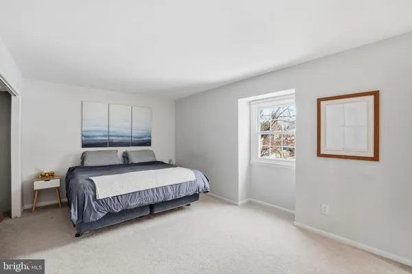 a spacious bedroom with a bed and a window