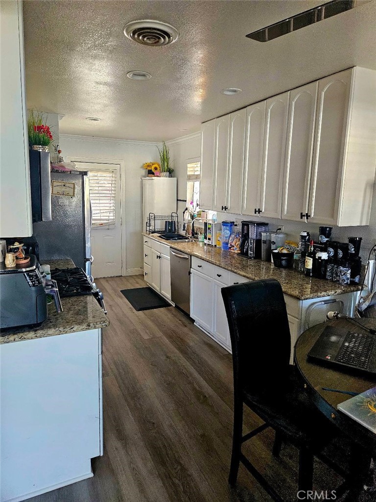 19263 Easton Street Rialto, CA 92376 - Photo 2 of 16 a kitchen with a table chairs stove and cabinets