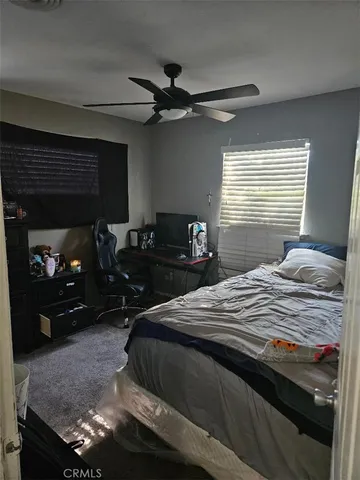 a bedroom with a bed and a ceiling fan