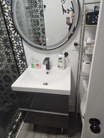 a bathroom with a sink and mirror with toilet