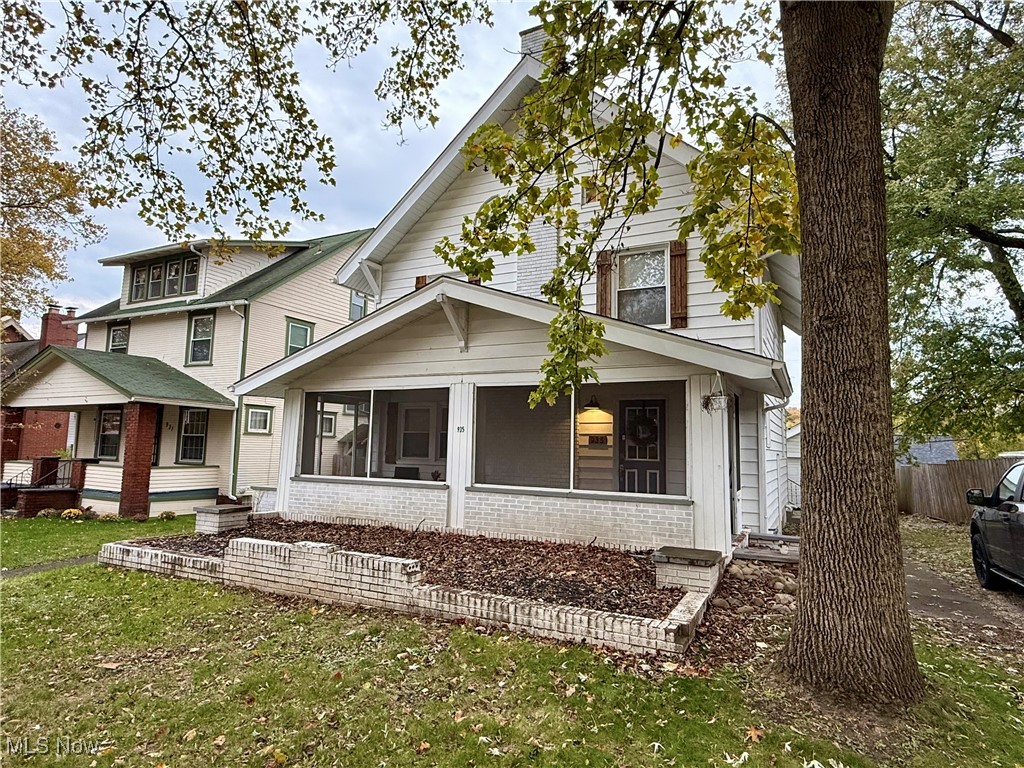View of front of house featuring brick siding, a porch, and a sunroom