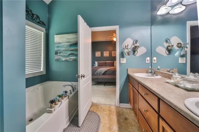 a en suite spacious bathroom with a granite countertop tub and a large mirror