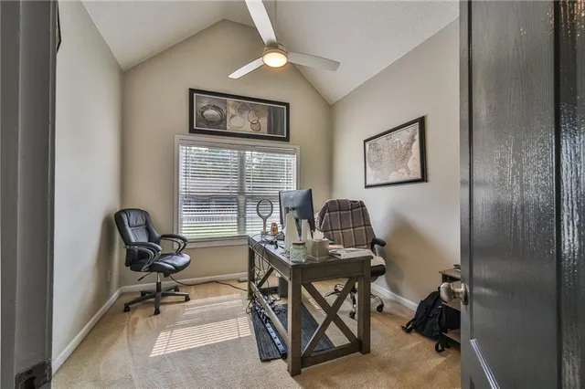 a view of a workspace with furniture and a window