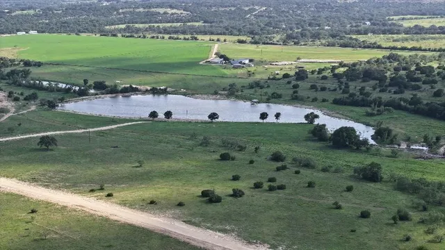 a view of a water pond with green field