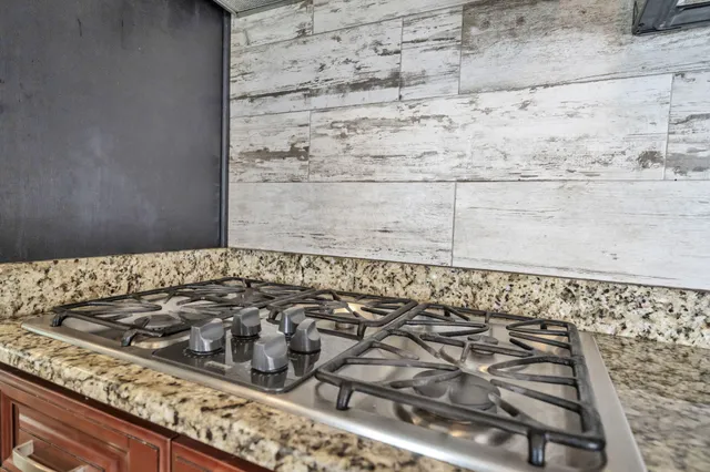 a view of an empty room with a window and kitchen view