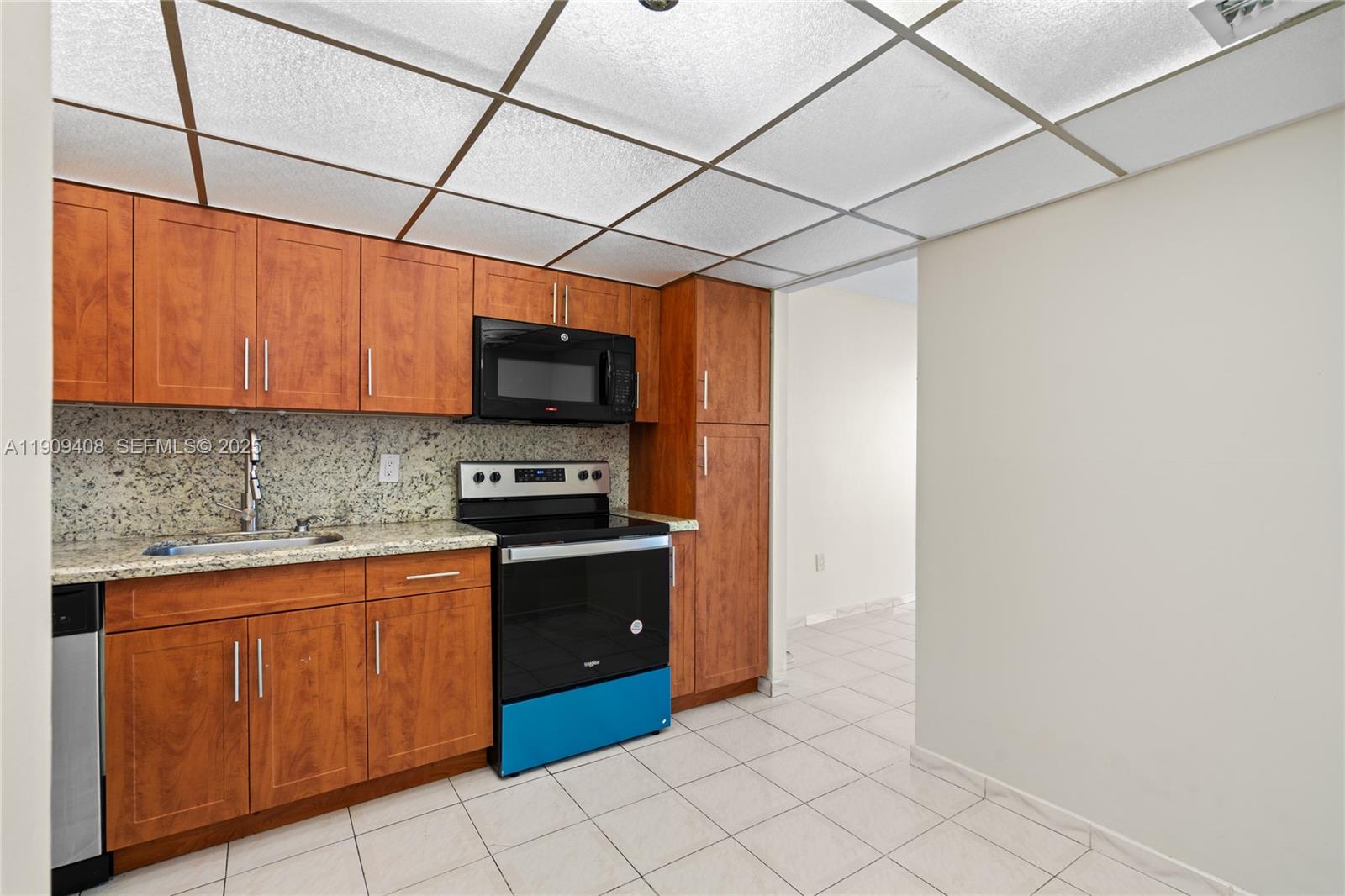 4101 Pine Tree Drive, Unit 802 Miami Beach, FL 33140 - Photo 11 of 58 a kitchen with granite countertop a sink and cabinets