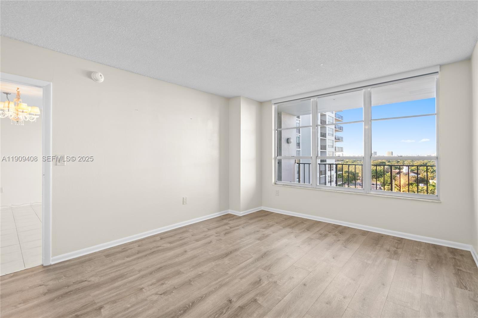 4101 Pine Tree Drive, Unit 802 Miami Beach, FL 33140 - Photo 14 of 58 an empty room with wooden floor and windows