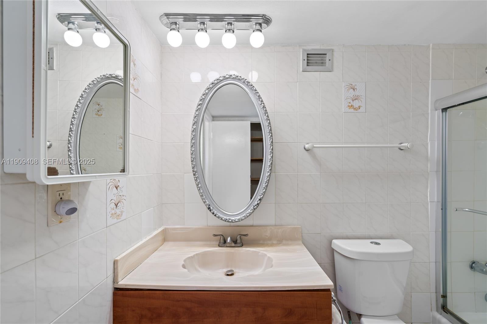 4101 Pine Tree Drive, Unit 802 Miami Beach, FL 33140 - Photo 18 of 58 a bathroom with a sink a toilet and a mirror