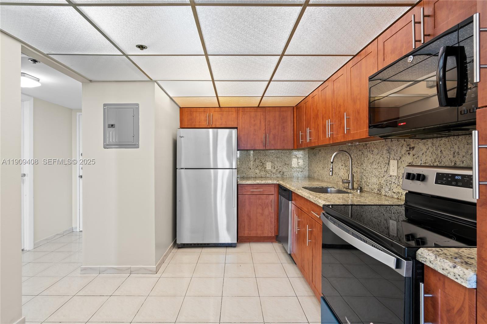 4101 Pine Tree Drive, Unit 802 Miami Beach, FL 33140 - Photo 9 of 58 a kitchen with stainless steel appliances granite countertop a refrigerator a stove and a sink
