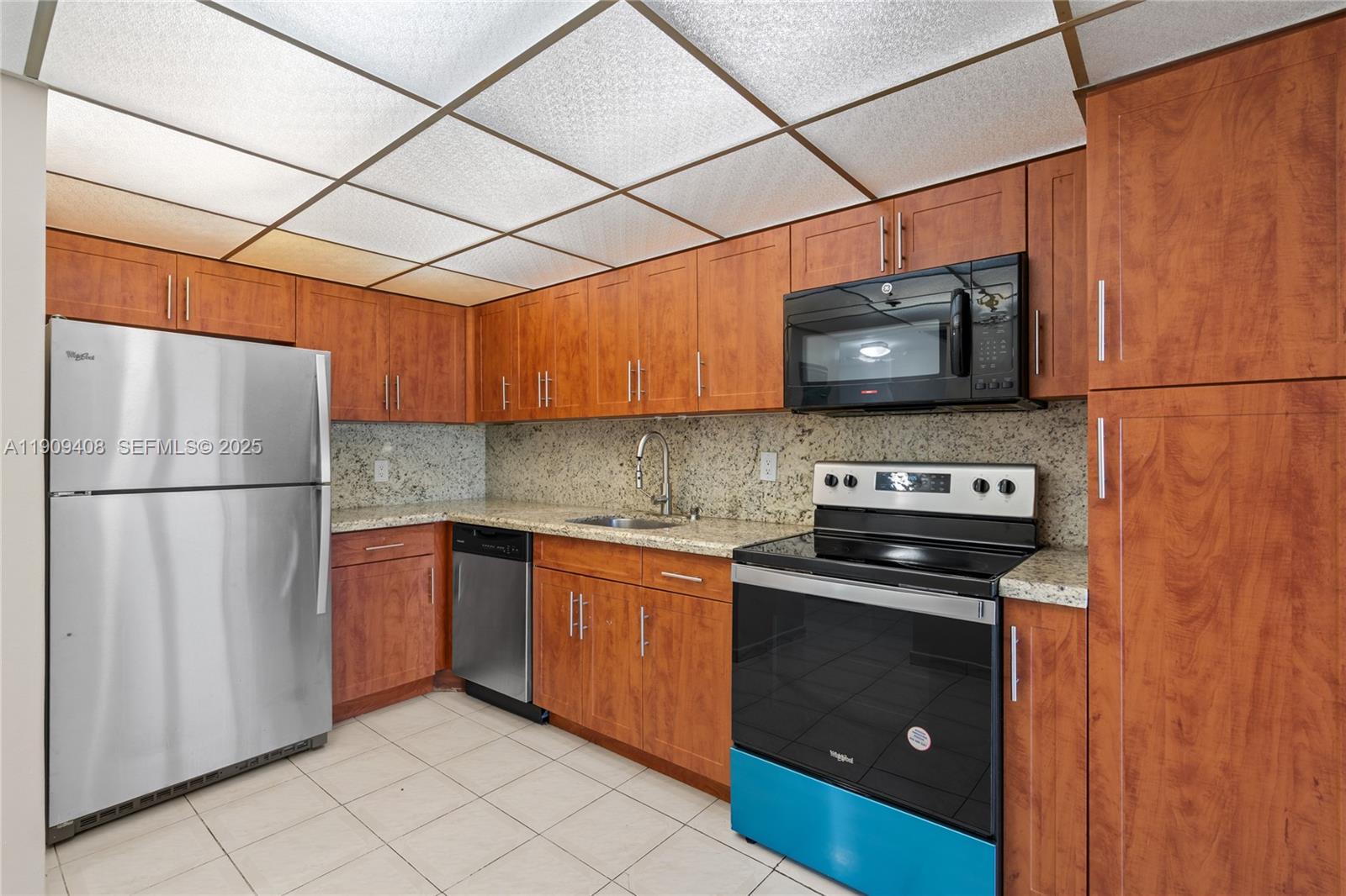 4101 Pine Tree Drive, Unit 802 Miami Beach, FL 33140 - Photo 10 of 58 a kitchen with stainless steel appliances granite countertop a stove a refrigerator and a microwave