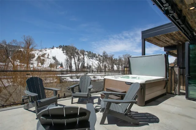 a view of a patio with a table and chairs in front of it