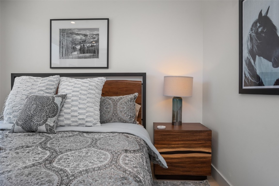 655 Yampa Street, Unit R1 Steamboat Springs, CO 80487 - Photo 23 of 49 a bedroom with a bed and a lamp on dresser