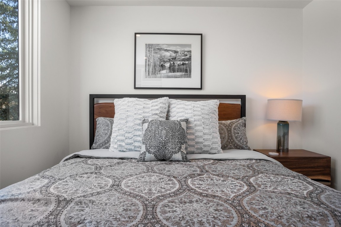 655 Yampa Street, Unit R1 Steamboat Springs, CO 80487 - Photo 24 of 49 a large bed sitting in a bedroom next to a lamp