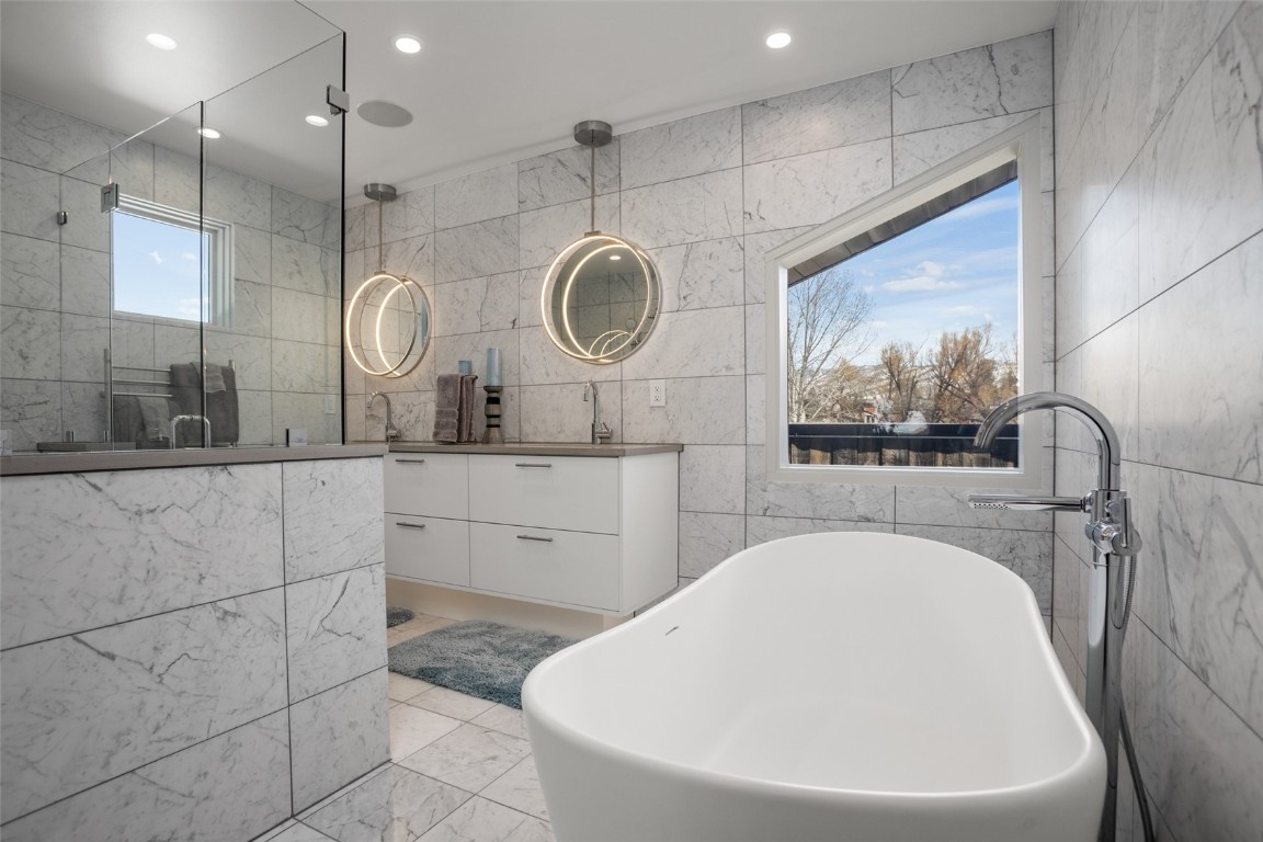 655 Yampa Street, Unit R1 Steamboat Springs, CO 80487 - Photo 35 of 49 a bathroom with a bathtub a sink and a mirror