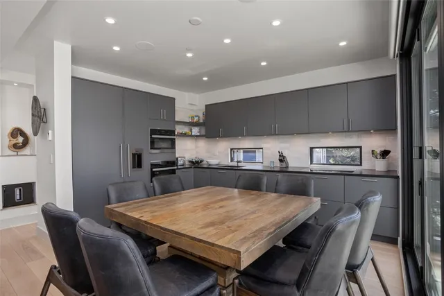 a kitchen with a dining table chairs and refrigerator