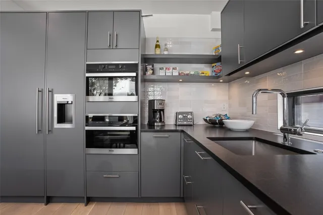 a kitchen with stainless steel appliances a sink a stove and cabinets