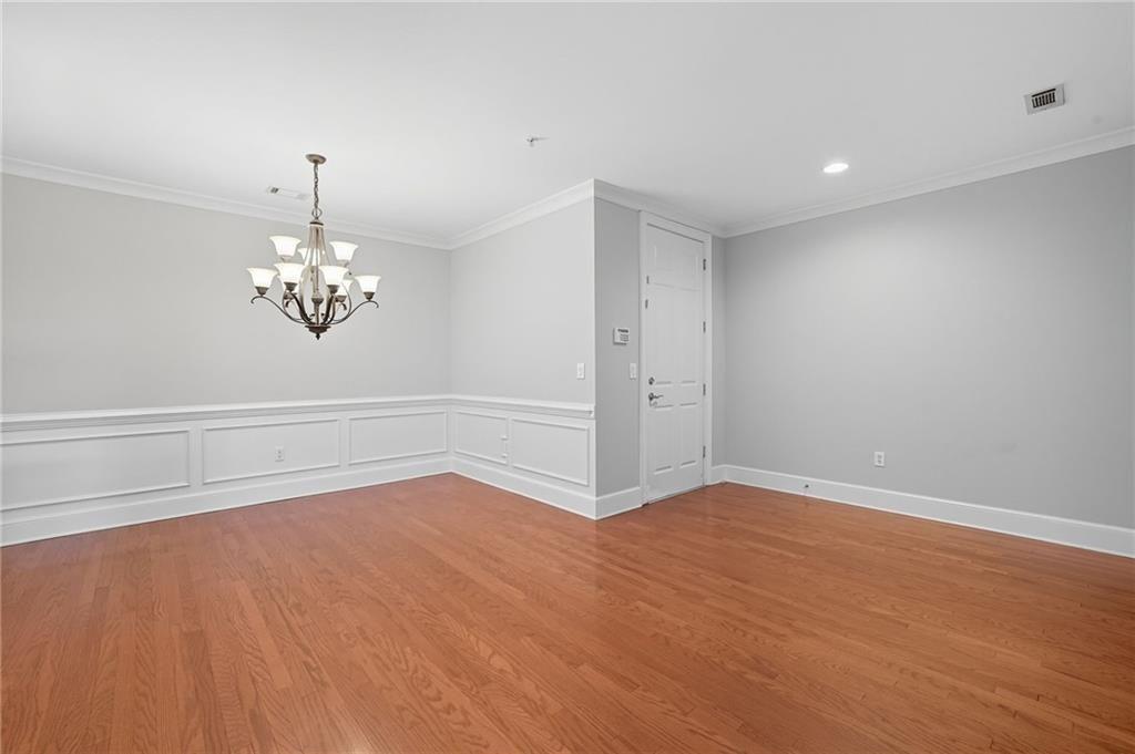 4950 Ivy Ridge Drive Southeast, Unit 203 Atlanta, GA 30339 - Photo 12 of 39 a view of empty room with wooden floor and chandelier