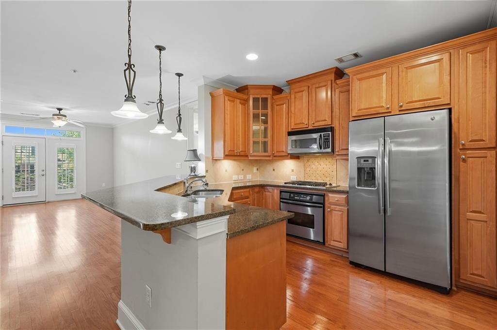 4950 Ivy Ridge Drive Southeast, Unit 203 Atlanta, GA 30339 - Photo 14 of 39 a kitchen with stainless steel appliances granite countertop a refrigerator a sink and a stove