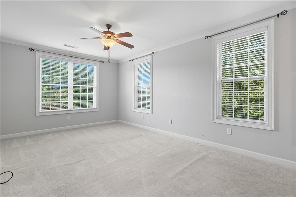 4950 Ivy Ridge Drive Southeast, Unit 203 Atlanta, GA 30339 - Photo 20 of 39 an empty room with chandelier fan and windows