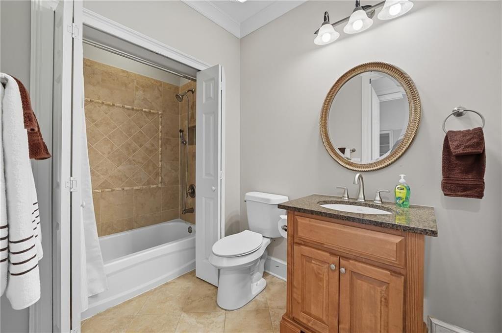4950 Ivy Ridge Drive Southeast, Unit 203 Atlanta, GA 30339 - Photo 26 of 39 a bathroom with a granite countertop toilet a sink and a mirror