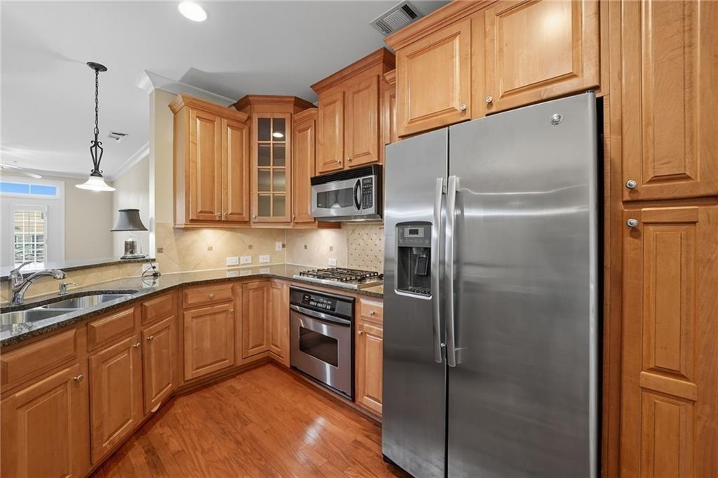 4950 Ivy Ridge Drive Southeast, Unit 203 Atlanta, GA 30339 - Photo 6 of 39 a kitchen with stainless steel appliances granite countertop a refrigerator a sink and white cabinets