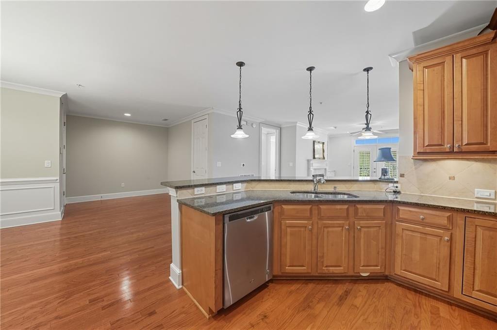 4950 Ivy Ridge Drive Southeast, Unit 203 Atlanta, GA 30339 - Photo 9 of 39 a kitchen with stainless steel appliances granite countertop a sink a stove a refrigerator and island with wooden floor