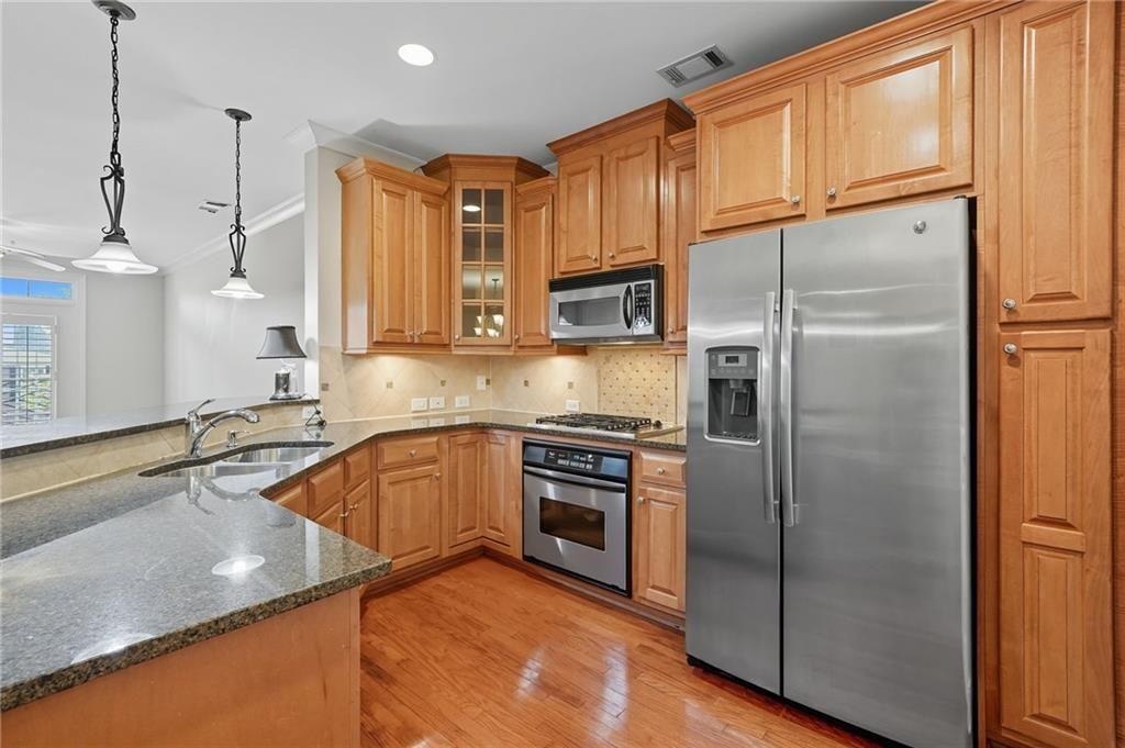 4950 Ivy Ridge Drive Southeast, Unit 203 Atlanta, GA 30339 - Photo 10 of 39 a kitchen with stainless steel appliances granite countertop a refrigerator a sink and a stove