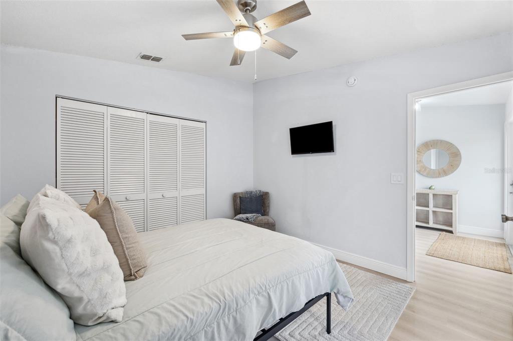 311 Poinsettia Road Anna Maria, FL 34216 - Photo 22 of 36 a bedroom with a bed and a flat tv screen on the dresser