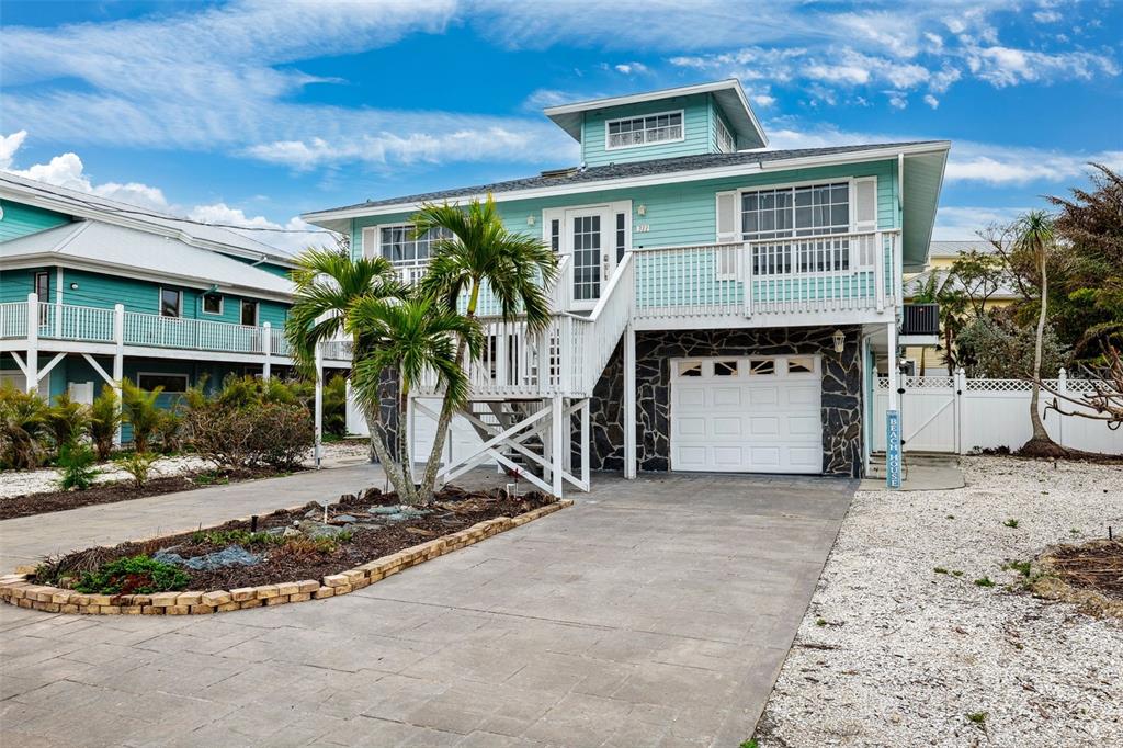 311 Poinsettia Road Anna Maria, FL 34216 - Photo 4 of 36 a front view of a house with a yard and garage